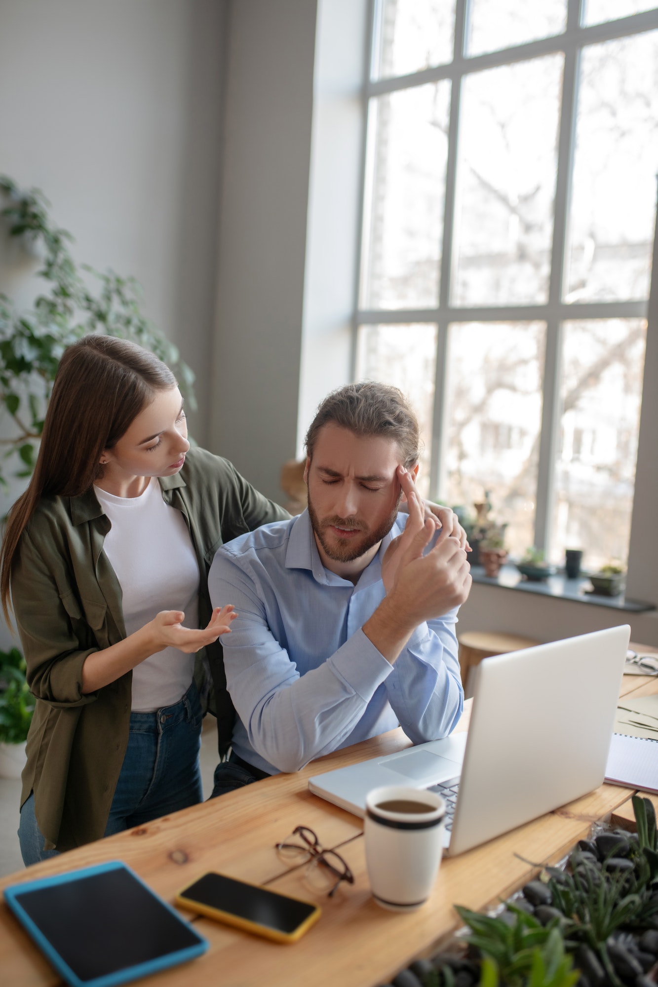 Woman helping her colleague having a headache